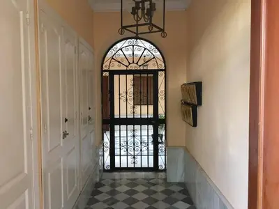 a hallway with a door with a wrought iron gate at El mirador del Mentidero in Cádiz