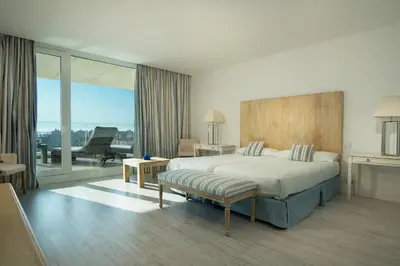 a hotel room with a bed and a balcony at Suites Puerto Sherry in El Puerto de Santa María