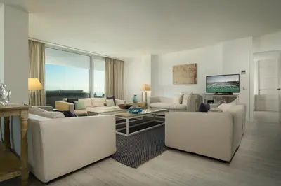 a living room with white furniture and a large window at Suites Puerto Sherry in El Puerto de Santa María