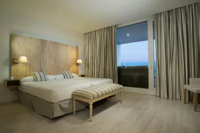 a bedroom with a large bed and a large window at Suites Puerto Sherry in El Puerto de Santa María