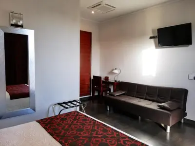 a living room with a couch and a tv on the wall at Hotel LB Lebrija by MA 22 Puntos in Lebrija