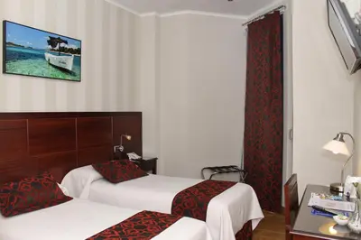 a hotel room with two beds and a window at Hotel LB Lebrija by MA 22 Puntos in Lebrija