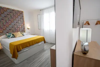 a bedroom with a bed with a yellow blanket at Apartamento Gran Sol de Cadiz in Cádiz