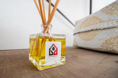 a bottle of whiskey sitting on a table next to a bed at Apartamento Gran Sol de Cadiz in Cádiz