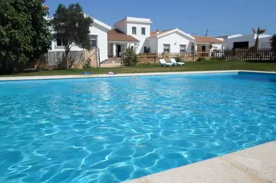 a large blue swimming pool in front of a house at Hotel Rural Casa Fina - Adults Recommended in Conil de la Frontera