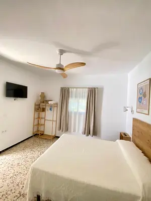 a bedroom with a white bed and a ceiling fan at Hotel Rural Casa Fina - Adults Recommended in Conil de la Frontera
