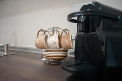 a group of cups sitting on a counter next to a mixer at Acogedor y luminoso apartamento in Cádiz