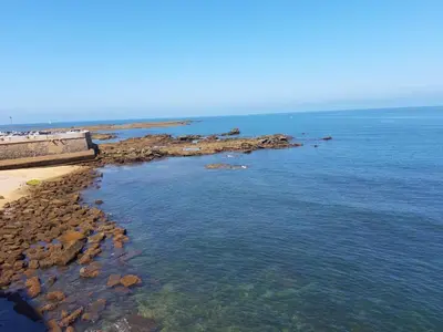 a view of the ocean from a beach with rocks at Acogedor y luminoso apartamento in Cádiz