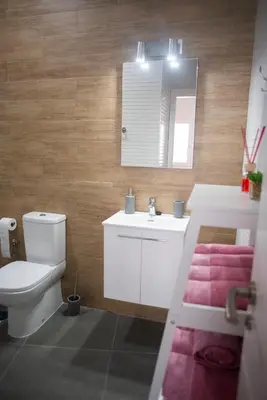a bathroom with a toilet and a sink and a mirror at Acogedor y luminoso apartamento in Cádiz
