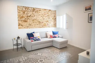 a living room with a white couch with pillows at Acogedor y luminoso apartamento in Cádiz