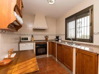 a kitchen with wooden cabinets and a sink and a window at Holiday Home Amado by Interhome in Conil de la Frontera