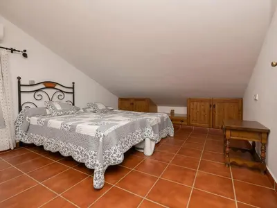 a bedroom with a bed and a table on a tile floor at Holiday Home Amado by Interhome in Conil de la Frontera