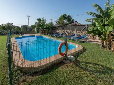 a fence around a swimming pool in a yard at Holiday Home Amado by Interhome in Conil de la Frontera