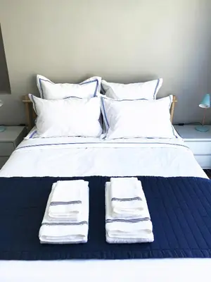 a white bed with three folded towels on it at El Palomar de Menacho in Cádiz
