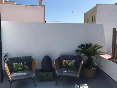 two chairs and a plant on a balcony at El Palomar de Menacho in Cádiz