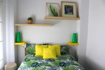 a living room with a couch with yellow pillows at Casa Alegría in Jerez de la Frontera