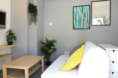 a living room with a white couch and a table at Casa Alegría in Jerez de la Frontera