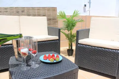 a table with a glass of wine and a plate of fruit at Casa Alegría in Jerez de la Frontera