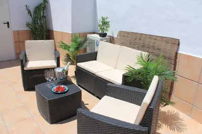 a patio with two chairs and a table at Casa Alegría in Jerez de la Frontera
