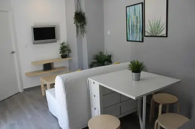 a living room with a white couch and a table at Casa Alegría in Jerez de la Frontera