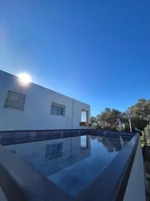 a swimming pool in front of a white building at Casa Rural Vacacional in Puerto Real