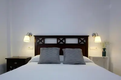 two gray pillows sitting on top of a bed at Sanlúcar Apart Airen!! in Sanlúcar de Barrameda