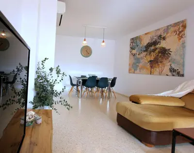 a living room with a couch and a table and chairs at Sanlúcar Apart Airen!! in Sanlúcar de Barrameda