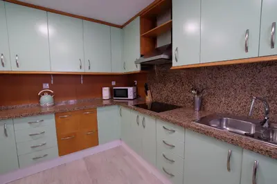 a kitchen with white cabinets and a sink at Fabuloso Ático con vistas al mar in Cádiz
