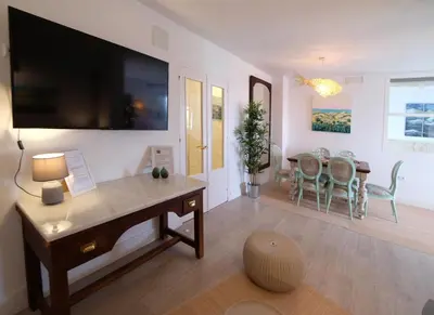 a living room with a desk and a dining room at Fabuloso Ático con vistas al mar in Cádiz