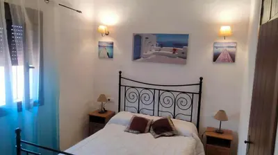 a bedroom with a bed and three pictures on the wall at Cortijo El Almendro, Urb. Fuente del Gallo, Conil in Conil de la Frontera
