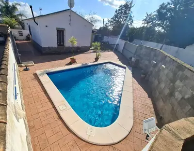 a large swimming pool in a backyard with a house at Cortijo El Almendro, Urb. Fuente del Gallo, Conil in Conil de la Frontera
