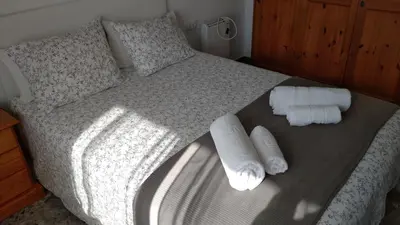 a bed with two rolled up towels on it at BNB LOLA - Habitacion con Baño privado en el pasillo y aire acondicionado in Puerto Real