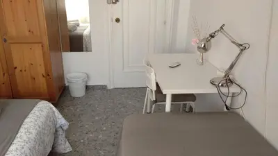 a bedroom with a desk with a lamp and a bed at BNB LOLA - Habitacion con Baño privado en el pasillo y aire acondicionado in Puerto Real