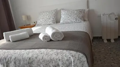 a bedroom with a bed with towels on it at BNB LOLA - Habitacion con Baño privado en el pasillo y aire acondicionado in Puerto Real