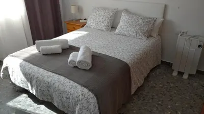 a bedroom with a bed with towels on it at BNB LOLA - Habitacion con Baño privado en el pasillo y aire acondicionado in Puerto Real