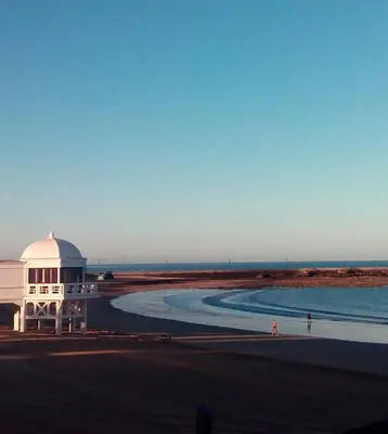 a building on the beach next to the water at Casa Crespo in Cádiz