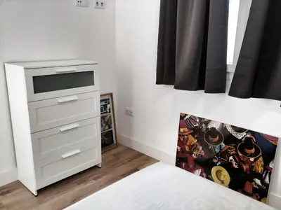 a bedroom with a bed and a dresser at Casa Crespo in Cádiz
