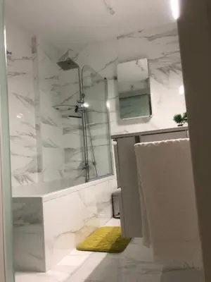 a white bathroom with a shower and a sink at Masai Victoria Beach. A 100 metros de la playa. in Cádiz