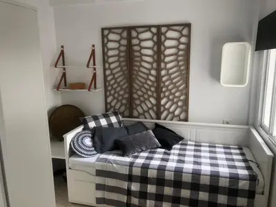 a bedroom with a bed with a checkered blanket at Masai Victoria Beach. A 100 metros de la playa. in Cádiz