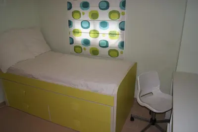 a small bedroom with a bed and a chair at Costa Ballena Cómodo Bajo con Piscina, Patio y 3 Dormitorios Parking free in Rota