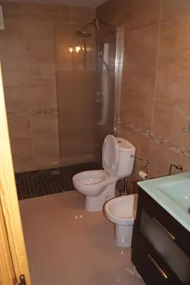 a bathroom with a toilet and a shower and a sink at Costa Ballena Cómodo Bajo con Piscina, Patio y 3 Dormitorios Parking free in Rota