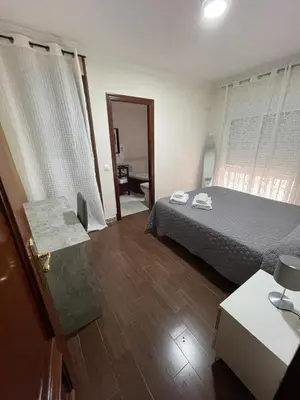 a bedroom with a bed and a table and a door at MARIÑIGUEZ APARTAMENT. in Jerez de la Frontera