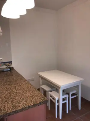 a small kitchen with a white table and stool at MARIÑIGUEZ APARTAMENT. in Jerez de la Frontera