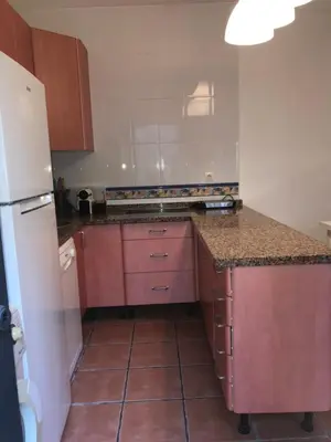 a kitchen with pink cabinets and a white refrigerator at MARIÑIGUEZ APARTAMENT. in Jerez de la Frontera
