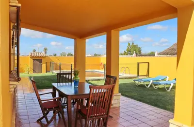 a patio with a table and chairs and a backyard at Casa Calas Boliña in Roche
