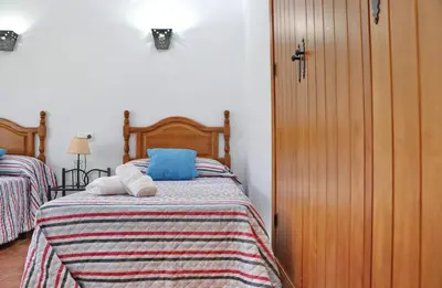 a bedroom with two beds with blue and white pillows at Casa Calas Boliña in Roche