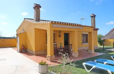 a small yellow house with a table and chairs at Casa Calas Boliña in Roche