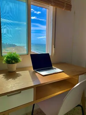 a laptop sitting on a desk in front of a window at Una ventana al mar in Rota