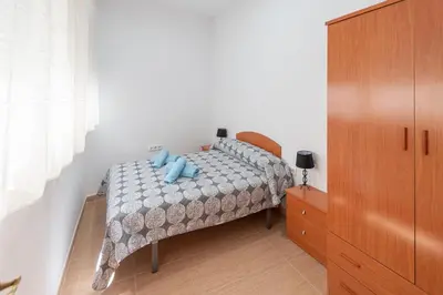 a bedroom with a bed with blue pillows on it at La casa de las margaritas in Cádiz
