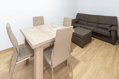 a dining room with a table and a couch at La casa de las margaritas in Cádiz